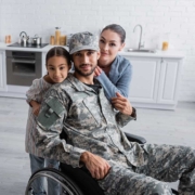 Two children and their veteran father in fatigues on a wheelchair. The RK360 must-have app for veterans help veteran families manage their healthcare records.